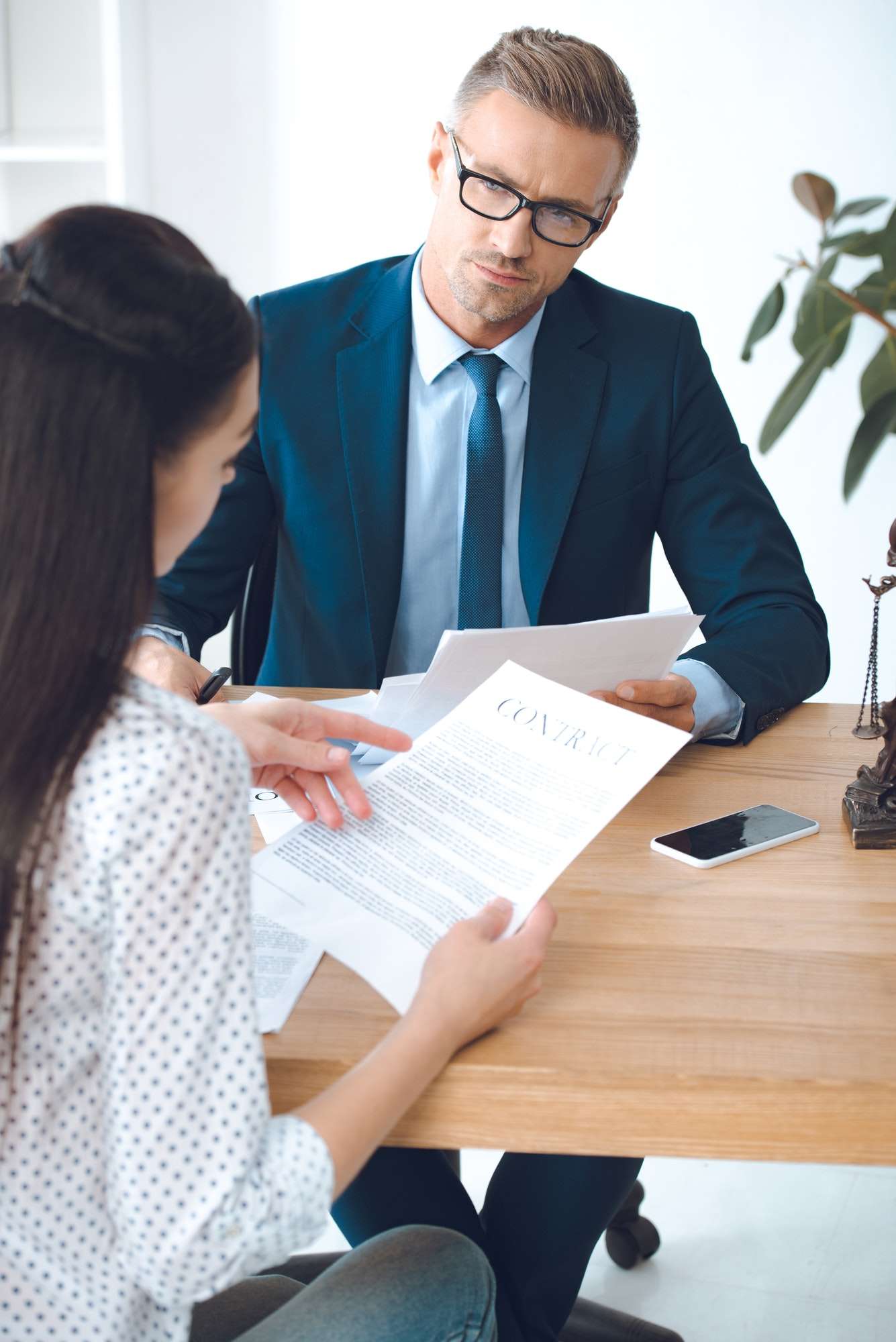 male-lawyer-looking-at-client-reading-contract.jpg male-lawyer-looking-at-client-reading-contract.jpg